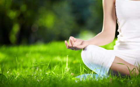 femme qui médite dans l'herbe