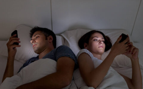 couple au lit avec leurs téléphones