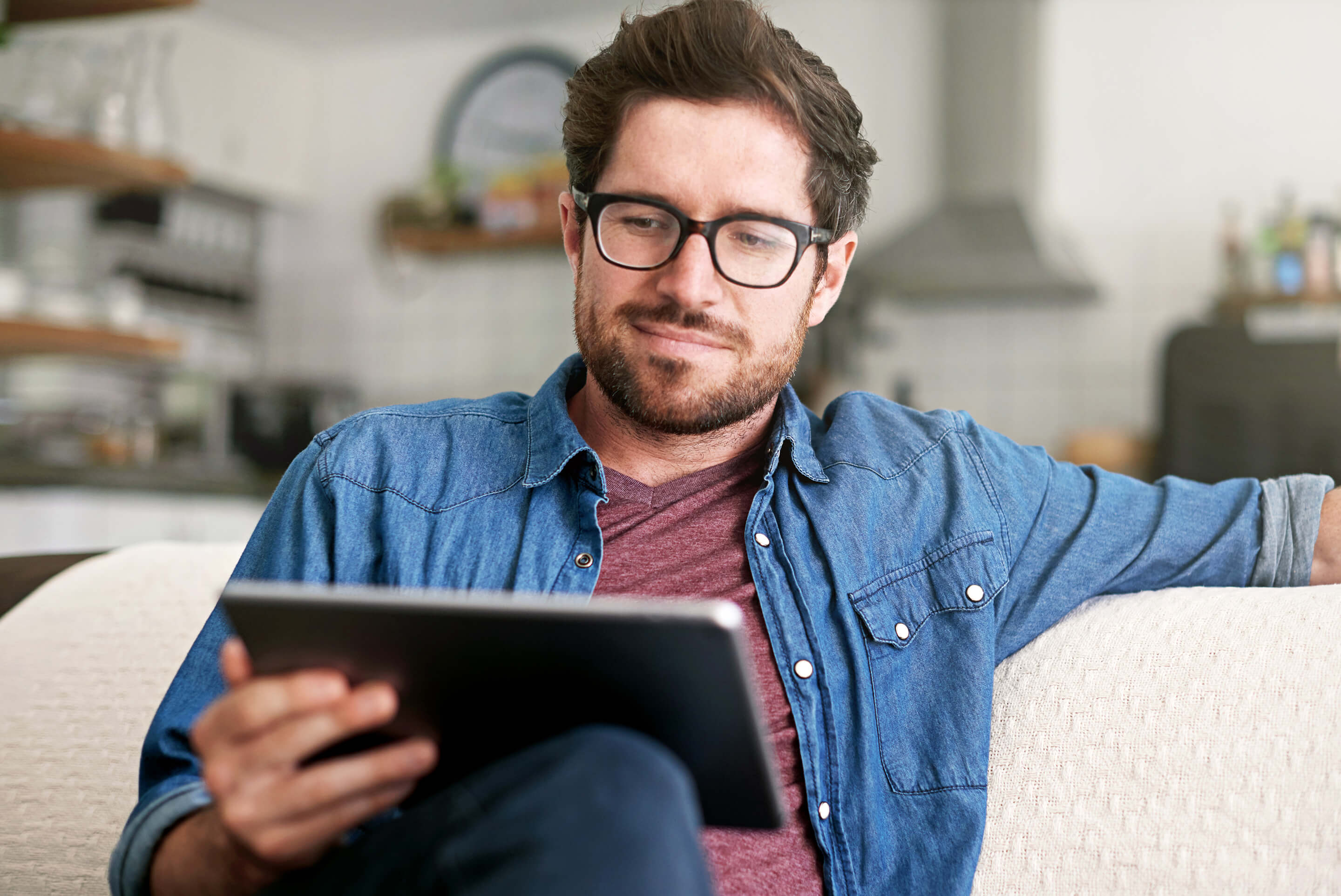homme lisant sur sa tablette tactile