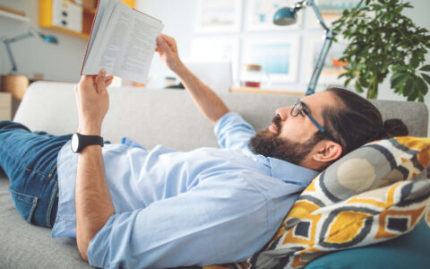 homme qui lit sur un canapé