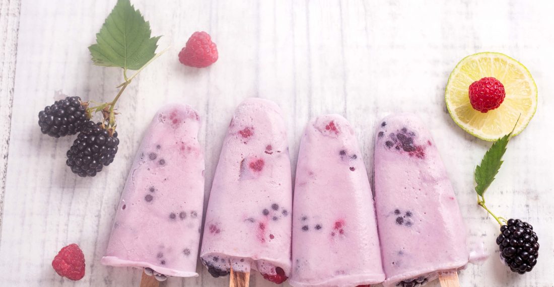 sucettes glacées au yogourt et petits fruits sur table en bois