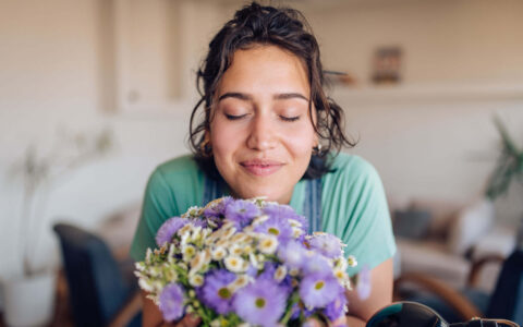femme respirant un bouquet de fleurs