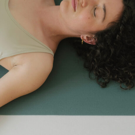 femme couchée sur un tapis de yoga