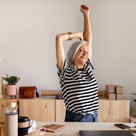 pauses-ressourcer-travail femme qui s'étire à son bureau