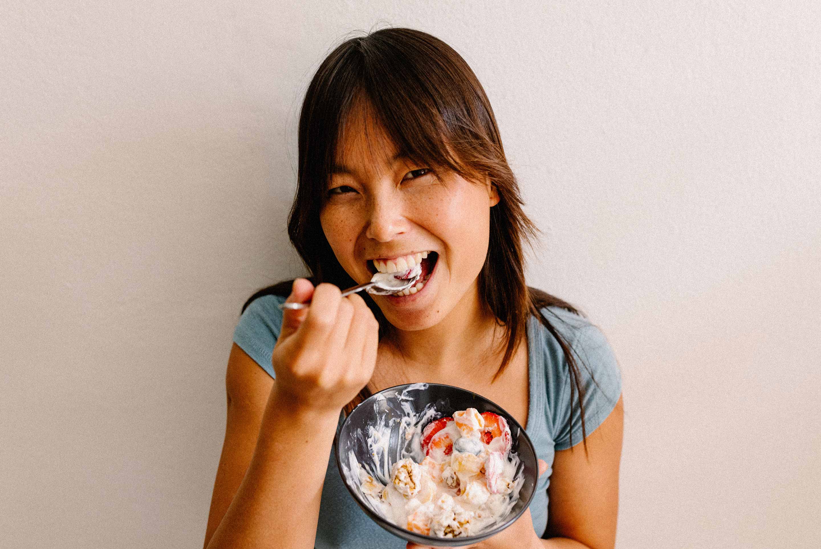 femme qui mange un bol de yogourt aux fruits