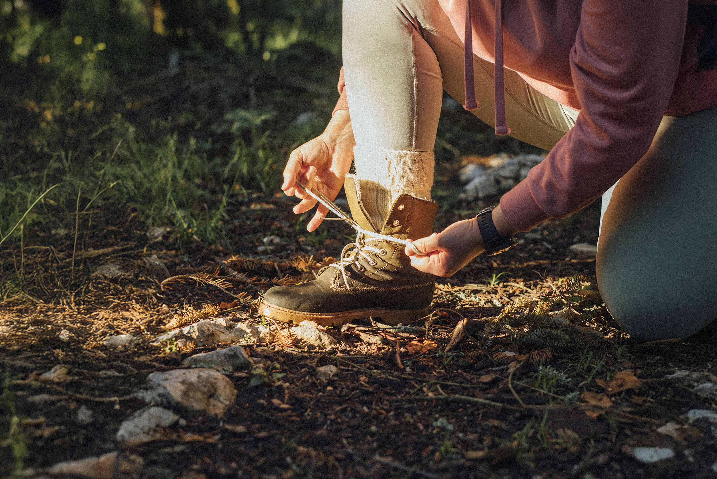 piqure-tique une personne qui attache sa botte de randonnée en nature