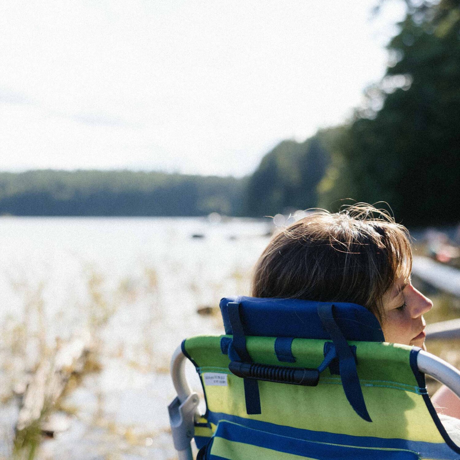 femme assise au bord d'un lac