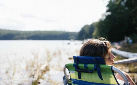 femme assise au bord d'un lac
