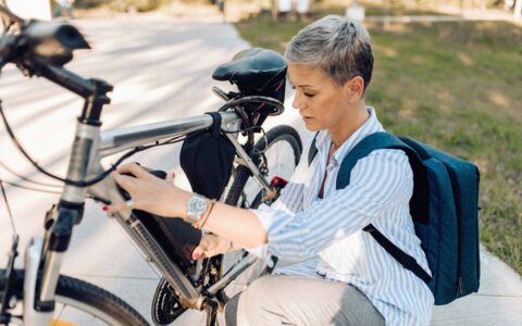 femme ajustant un vélo électrique