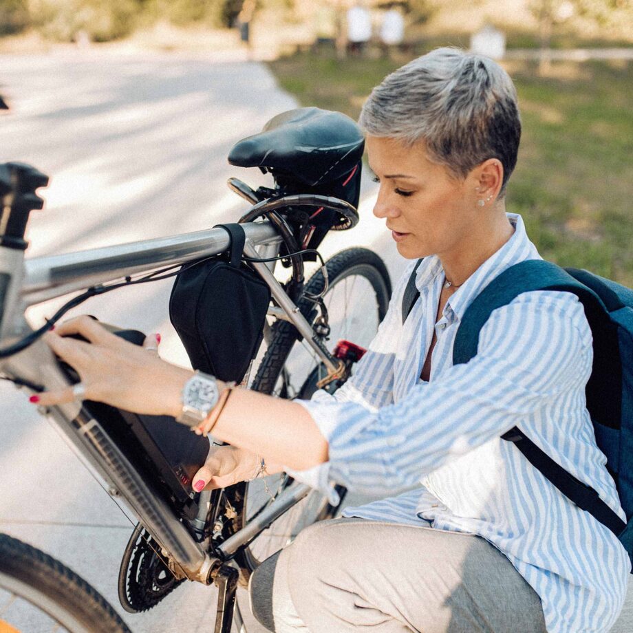 femme ajustant un vélo électrique