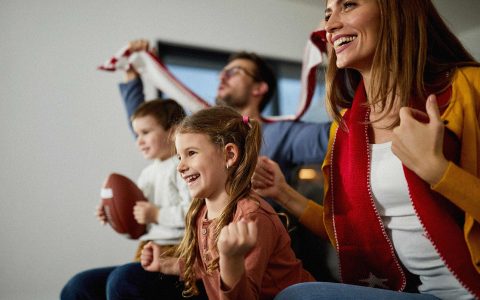 famille regardant un match è la télévision
