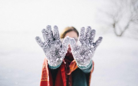 femme à l'extérieur l'hiver montrant ses mitaines