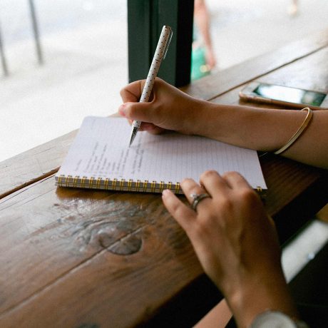 personne écrivant dans un cahier