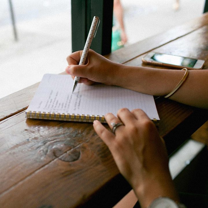 personne écrivant dans un cahier